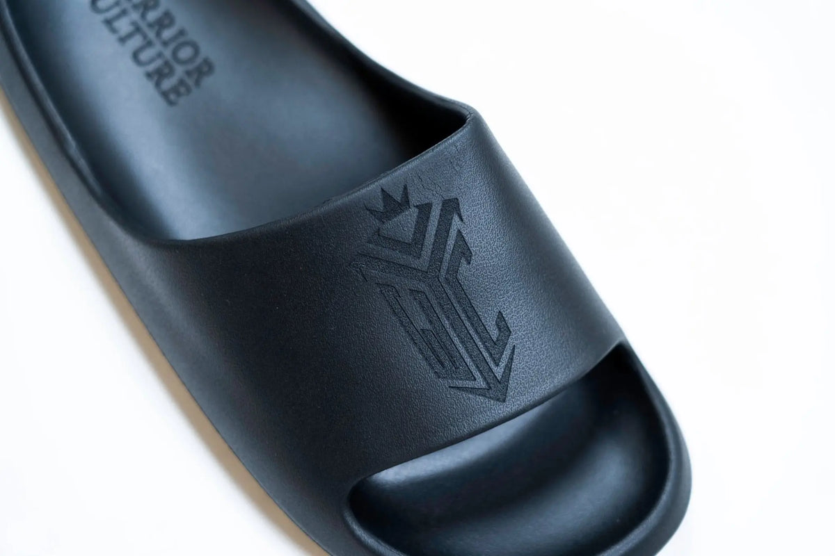 Frontier Recovery Sliders in Black, debossed Warrior Culture crest on the strap